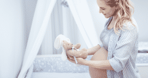 pregnant woman holding a teddy bear