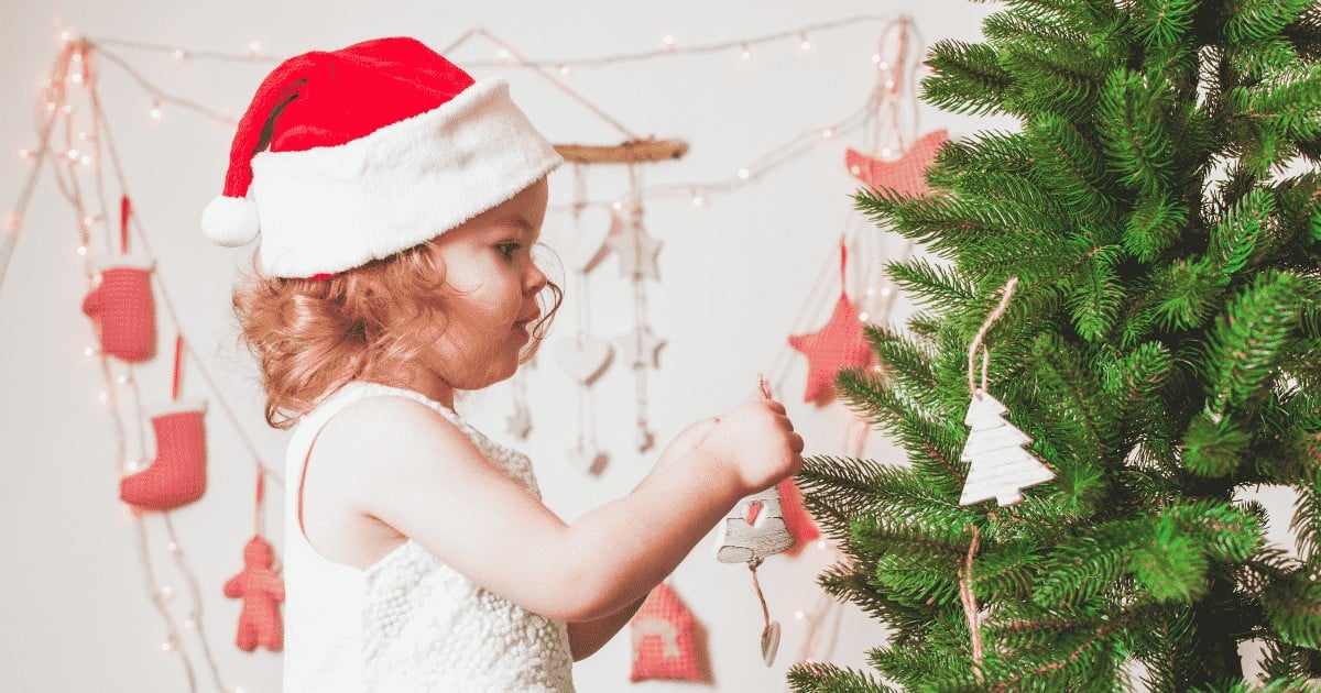 toddler decorating a tree