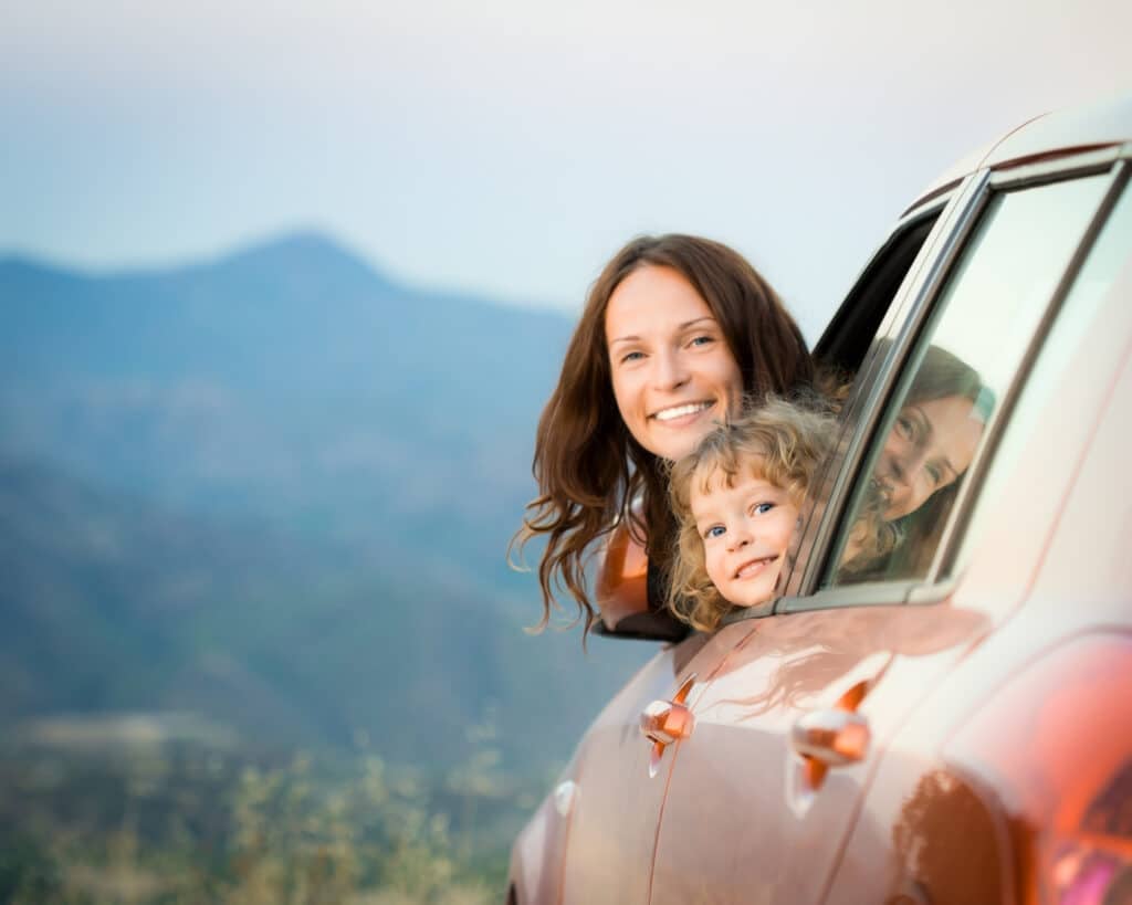 Mom and son smiling out of the car window