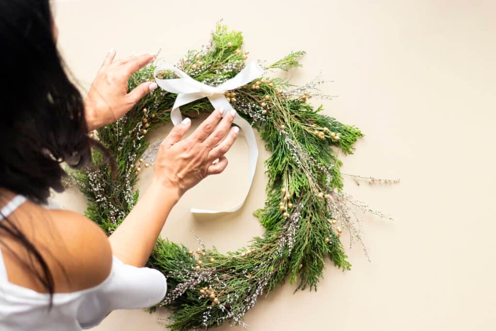 Cute woman decorates advent wreath with her hands