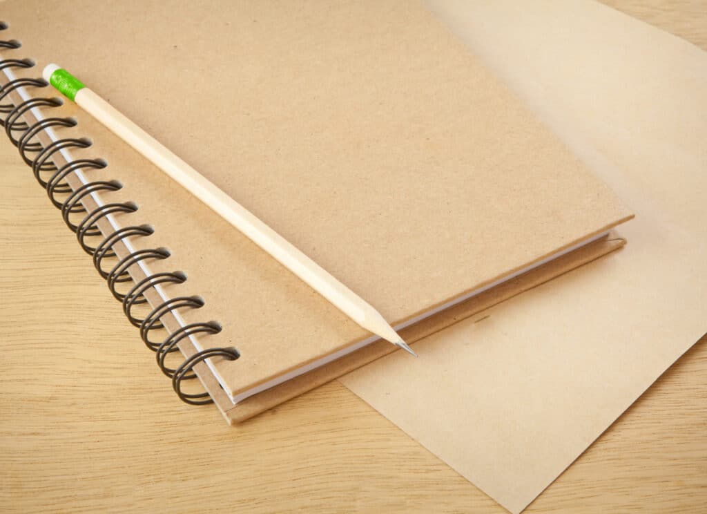 recycle notebook and wooden pencil on wood background